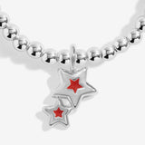Close-up of the double star charm with red detailing on Joma Jewellery's Make A Christmas Wish kids' bracelet