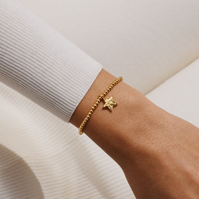 Joma Jewellery Merry Christmas gold-plated bracelet with layered star charm worn on a wrist