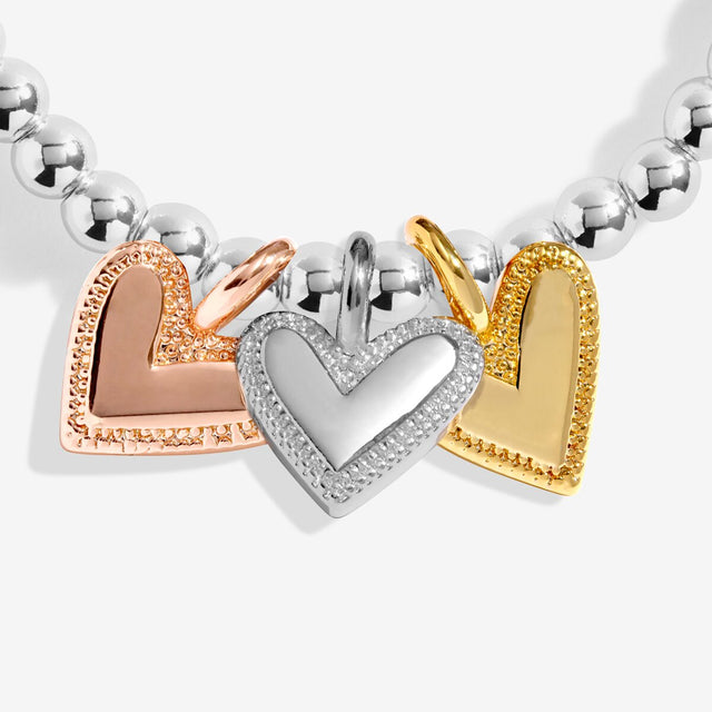 Silver, gold and rose gold heart charms on Joma Jewellery New Chapter bracelet