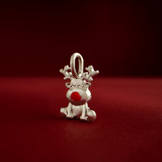 Joma Jewellery Rudolph reindeer charm with a red nose against a red background