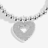 Close-up of the sparkling heart charm with a heart-shaped cut-out on Joma Jewellery's With Love silver-plated bracelet