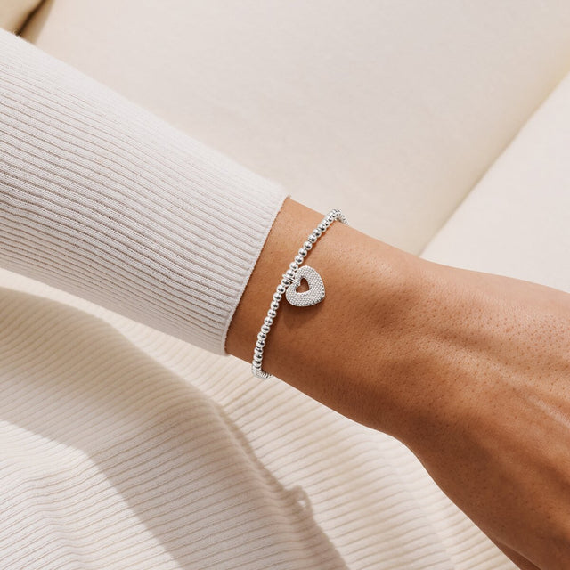 Joma Jewellery With Love silver-plated bracelet with sparkling heart charm with a heart-shaped cut-out worn on a wrist