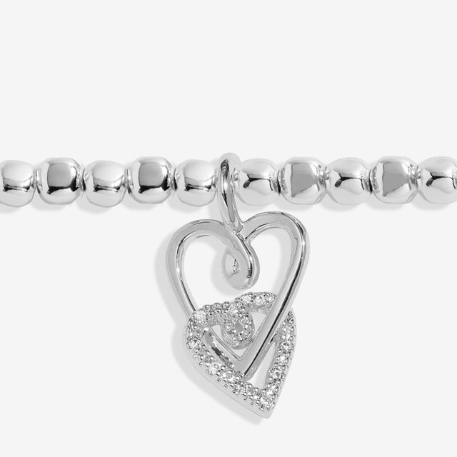 Close up of interlinked heart charms on silver friendship bracelet