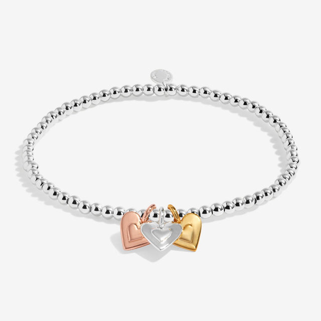 Silver beaded stretch bracelet with silver, gold and rose gold heart charms
