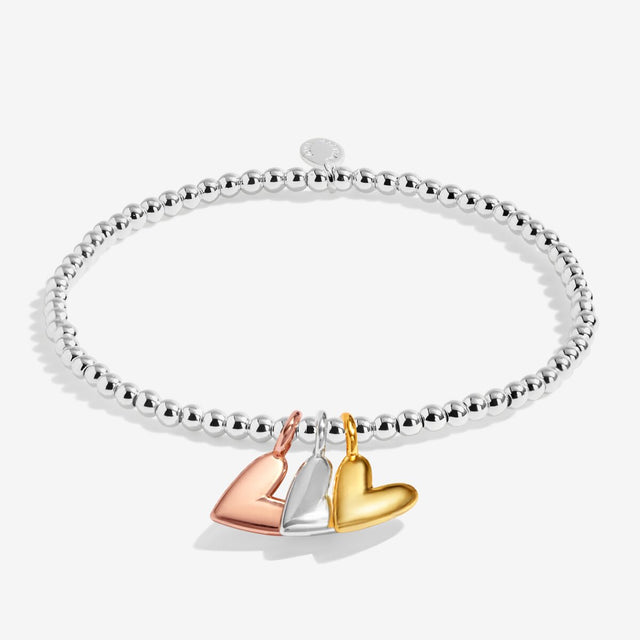 Silver beaded stretch bracelet with silver, gold and rose gold heart charms