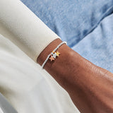 Mixed metal star charm thank you bracelet worn on wrist