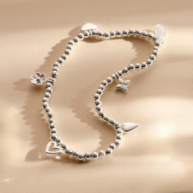 Joma Jewellery With Love silver charm bracelet styled on neutral background