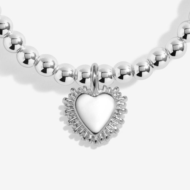 Heart charm detail on silver charm bracelet