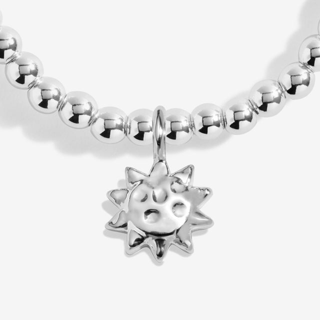 Sun charm detail on silver charm bracelet