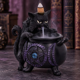 Spite’s Cauldron black cat backflow incense burner with cascading smoke on a dark table beside books