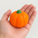 Pumpkin sensory squishy toy 7cm shown in an adult hand for scale