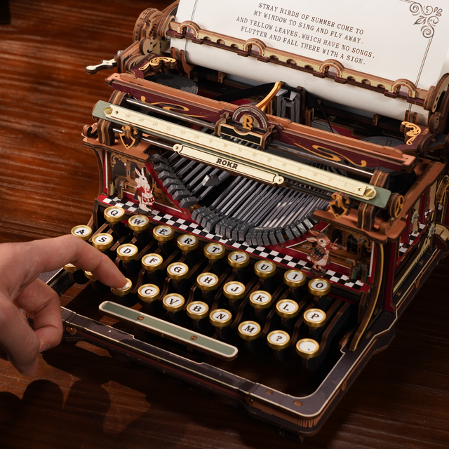 ROKR mechanical typewriter model with a hand pressing the working keys