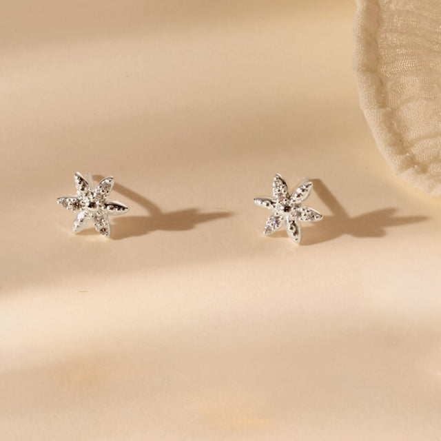 Silver flower earrings styled for everyday wear