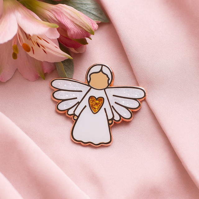 Angel of Friendship guardian angel pin displayed on pink fabric with floral details, symbolising warmth and affection.