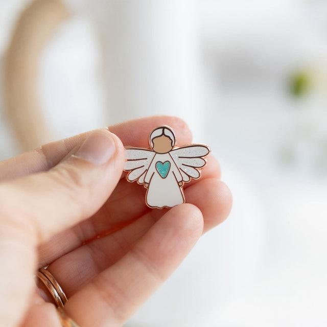 Splosh Angel of Hope pin held gently in hand, representing comfort, care, and the promise of brighter days.