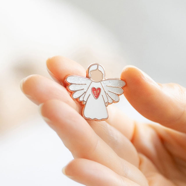 Splosh Angel of Strength Keepsake Pin held gently in hand, representing courage, empowerment, and protection.