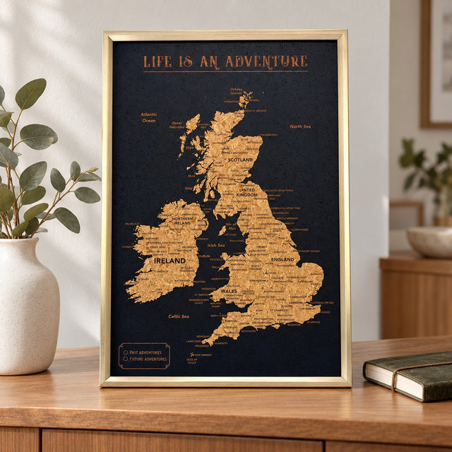 Splosh black UK & Ireland travel map with gold frame standing on wooden furniture in a neutral home setting