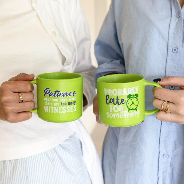 Two people holding green Splosh Cheeky Mugs with funny quotes – witty and humorous mugs for friends or work.