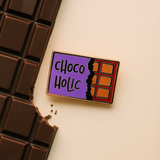 Splosh Chocolate Lover enamel pin styled on chocolate bar background