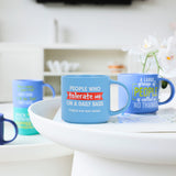 Splosh Cheeky Mug Tolerate on kitchen table, humorous blue mug with cheeky quote, funny novelty coffee cup for home or office use.