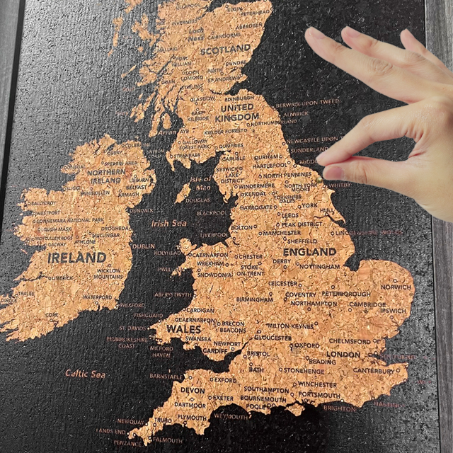 Close-up of a metallic pin being placed in the Splosh UK and Ireland cork map