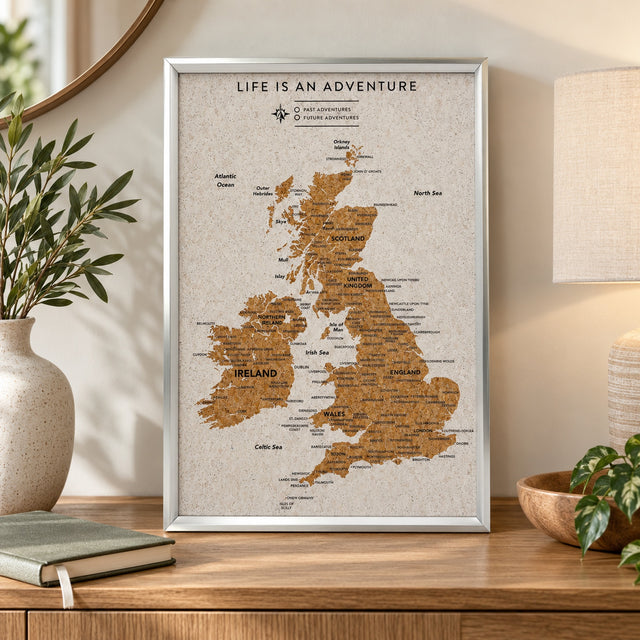 Splosh white UK & Ireland travel map with silver frame displayed on wooden furniture in a neutral home setting