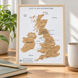 Splosh white UK & Ireland travel map with natural wood frame displayed on wooden furniture in a neutral home setting