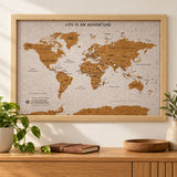 Splosh white World travel map with natural wood frame displayed on a wall above wooden furniture
