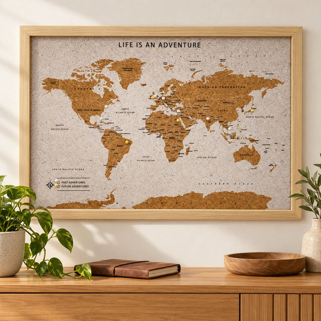 Splosh white World travel map with natural wood frame displayed on a wall above wooden furniture