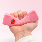 Pink strawberry butter slow-rise squishy toy being squeezed by hand