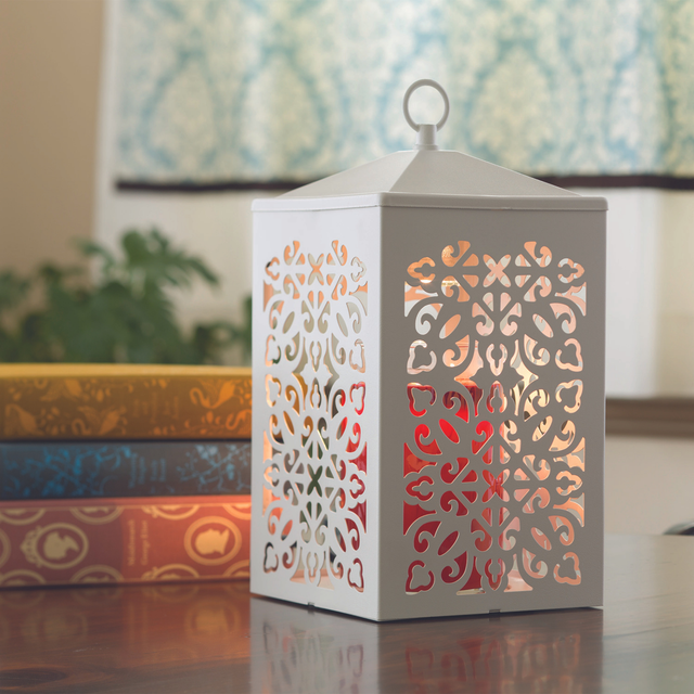 White Scroll candle warmer lamp illuminated in a home interior